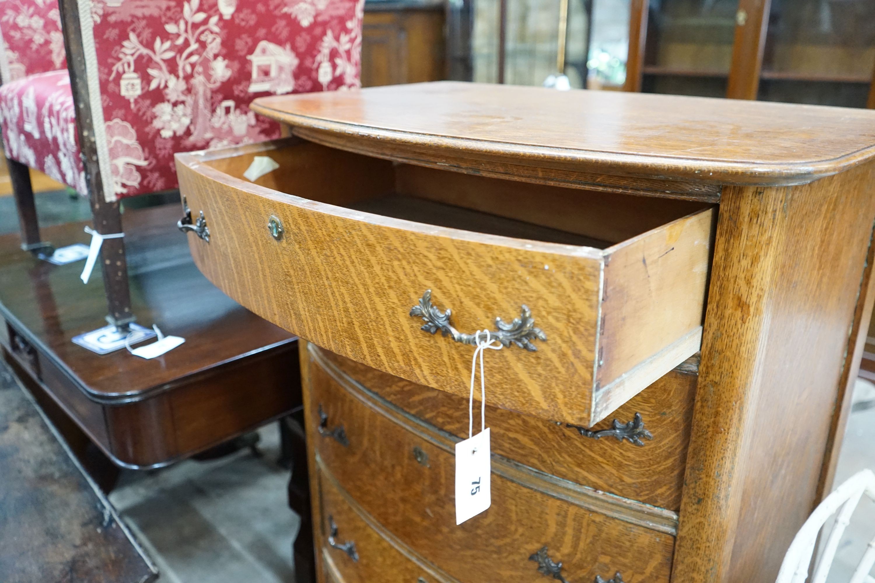 An early 20th century oak bow front tall chest, width 76cm, depth 49cm, height 123cm